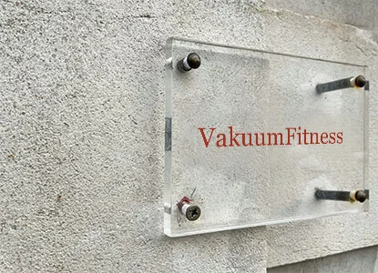 Zid s prozirnom pločom i natpisom VacuumFitness u modernom interijeru.